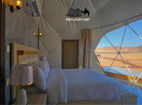 a bedroom with a tent with a bed and a window at MIRA LUXURY CAMp in Wadi Rum