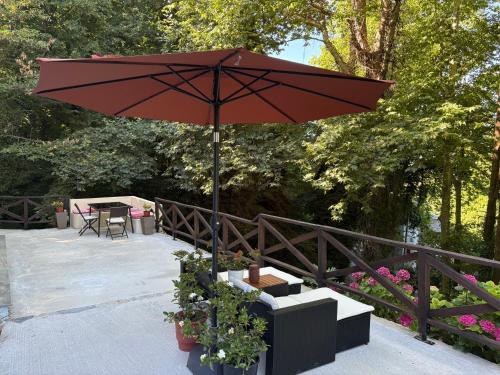 a red umbrella sitting on top of a patio at Pelion 7 Lives in Tsagarada