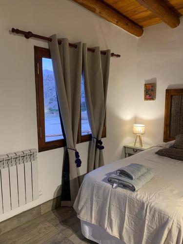 a bedroom with a bed and a window at Cabañas La Nochera in Tilcara