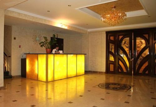 a lobby with a yellow counter in a room at ABAI INN - Nursaya in Taraz