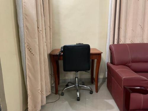a room with a desk and a chair next to a chair at EKA ELITE HOTEL in Lomé