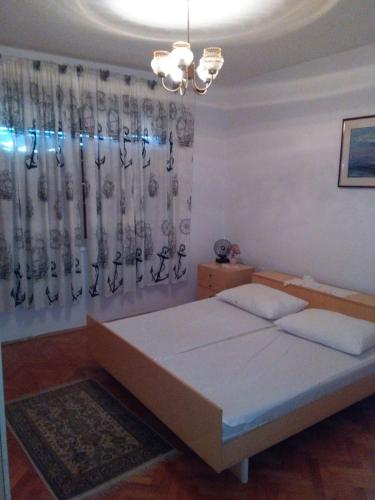 a bedroom with a bed and a chandelier at Gajeta in Betina