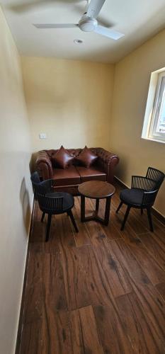 a living room with a leather couch and two chairs at Hotel Vaishno Bliss in Bhubaneshwar