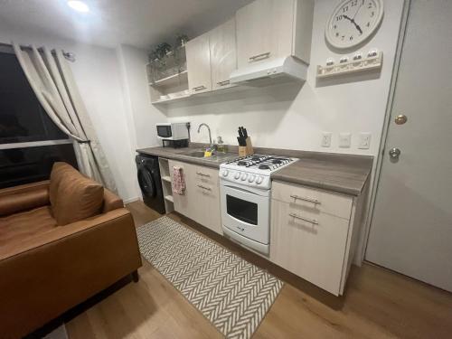 a small kitchen with a stove and a couch at Acogedor departamento en zona céntrica de la CDMX in Mexico City