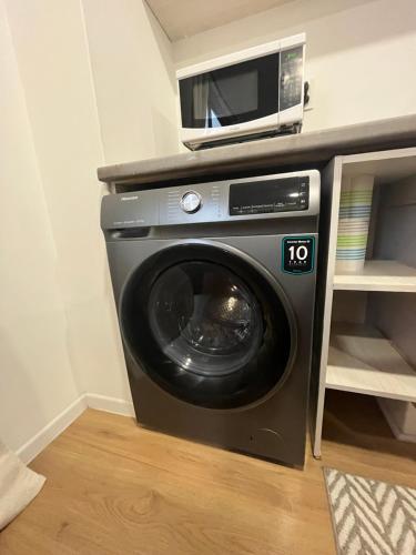 a washing machine with a microwave on top of it at Acogedor departamento en zona céntrica de la CDMX in Mexico City