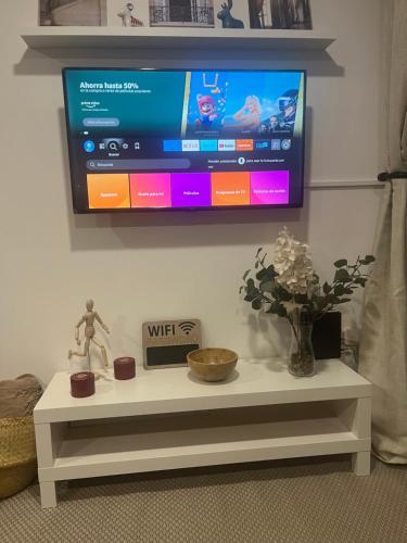 a tv hanging on a wall with a white table at Acogedor departamento en zona céntrica de la CDMX in Mexico City