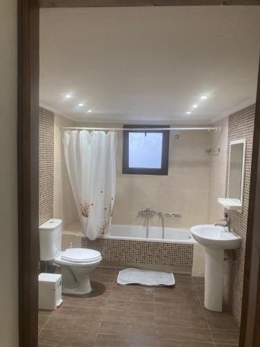 a bathroom with a tub and a toilet and a sink at Liberty-Studio N1 in Georgioupolis