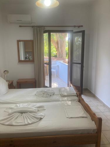 a bedroom with a bed with a view of a patio at Liberty-Studio N1 in Georgioupolis