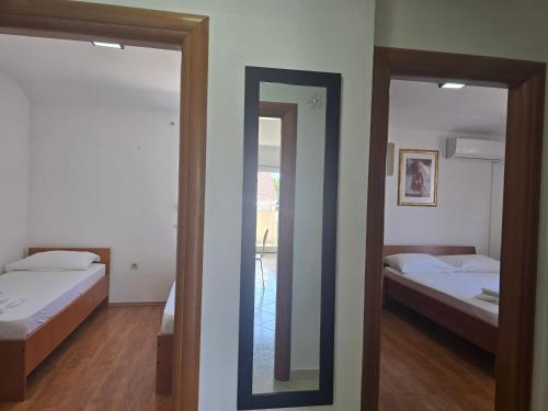 a mirror in a room with two beds and a bedroom at Apartment Paska in Novalja