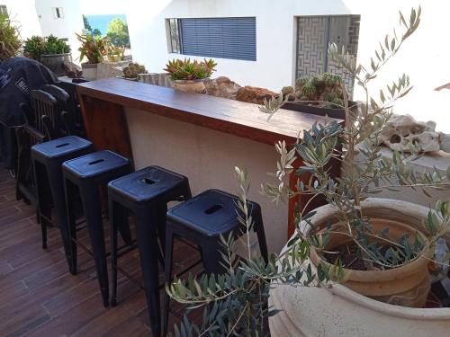 a bar with stools next to a counter with plants at Jaffa Getaway sea front, luxury Duplex, Port & Old City 2m walk in Tel Aviv