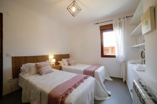 a hotel room with two beds and a window at Apartamento Balcón al Mediterráneo in Moraira