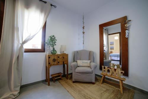 a living room with a chair and a mirror at Apartamento Balcón al Mediterráneo in Moraira