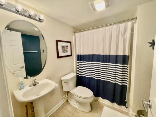 ein Badezimmer mit Waschbecken, Toilette und Spiegel in der Unterkunft Delano 3i in Rehoboth Beach