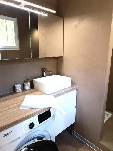 une cuisine avec une machine à laver et un évier dans l'établissement couché de soleil, à Patrimonio