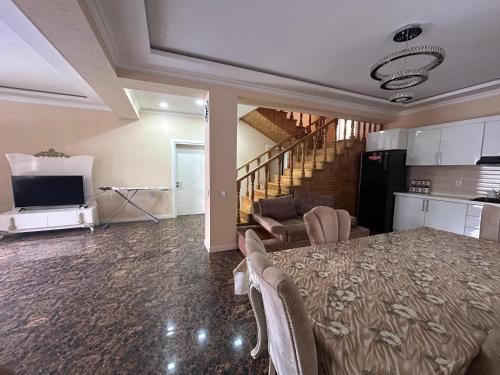 Una sala de estar con una cama y una cocina y escaleras. en Gabala Double villa, en Gabala