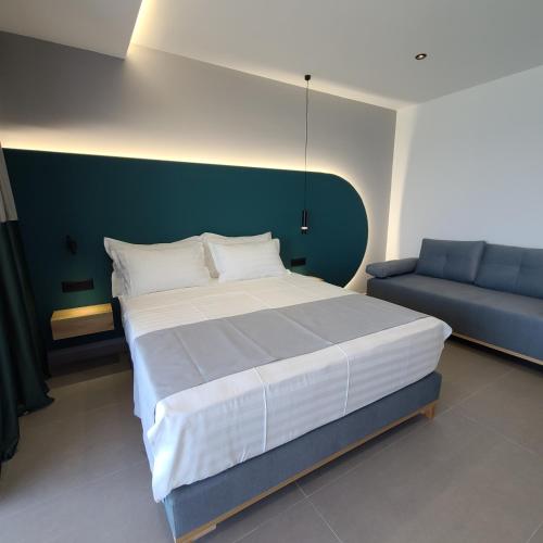 a bedroom with a large bed and a couch at Sunset Boulevard Hotel in Qeparo