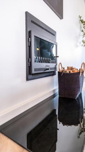 a fireplace with a television on a wall with a basket at The Hyacinth at Arbour Nature Estate in George
