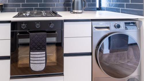 a stove and a washing machine in a kitchen at The Hyacinth at Arbour Nature Estate in George