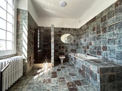 a bathroom with a tub and a shower and a sink at La Périgode - Magnifique demeure près des plages in Binic-Etables-sur-Mer