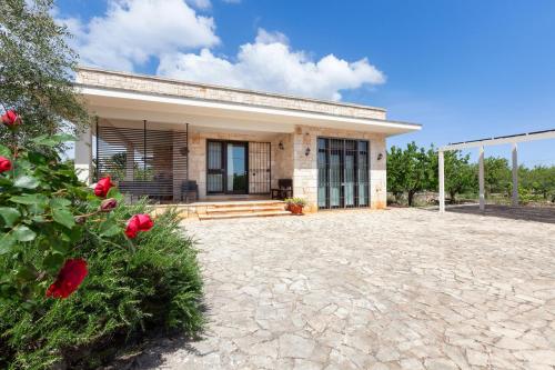 a house with red roses in front of it at HariHome in Triggianello