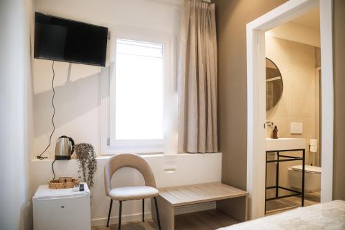 a bedroom with a window and a chair and a mirror at Studio Venice Mestre Centrale in Venice