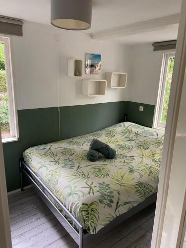 a bedroom with a bed with a backpack on it at Forest Cottage Hattem in Hattemerbroek