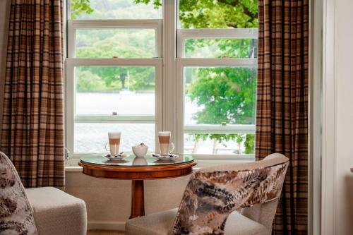 a room with a table and two chairs and a window at Lakeside Hotel and Spa in Newby Bridge