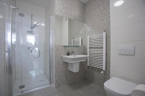 W łazience znajduje się prysznic, umywalka i toaleta. w obiekcie Impresja Restauracja Hotel w mieście Zambrów