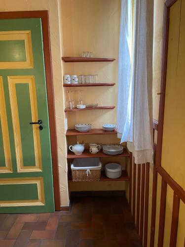 a room with a door and a shelf with dishes at Badehaus Villa Fiedrichs in Ilmenau