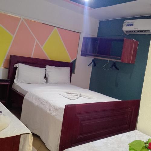 a bedroom with a bed with a colorful wall at Bali Hotel Palace in Yaoundé