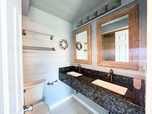 Un baño con dos lavabos y un espejo. en Saulsbury street 1a, en Dewey Beach