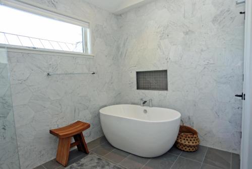 ein weißes Badezimmer mit Badewanne und Fenster in der Unterkunft Maryland avenue 35 in Rehoboth Beach