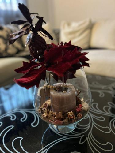 a glass vase with flowers and a candle on a table at Amaya Pine Central in Pondiás
