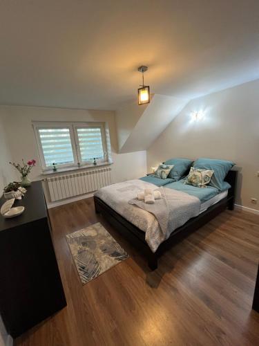 a bedroom with a bed with blue pillows at Apartament na poddaszu in Sandomierz