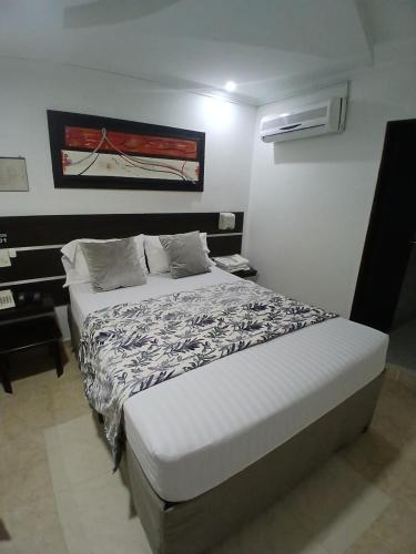 a bed in a small room with a bed sidx sidx sidx at Hotel Plaza Norte Cali in Cali