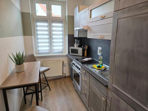 a small kitchen with a sink and a table at FeWo 5 Personen, Nähe Bahnhof, WLAN,Balkon in Halberstadt