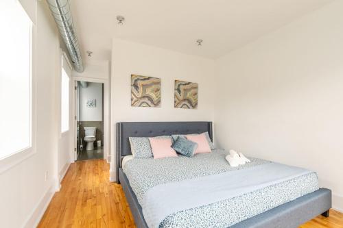 a bedroom with a bed with pink and blue pillows at Stylish & Pet-Friendly 2BR Suite in Trendy Leslieville with Portable AC Nearest Intersection Eastern Ave in Toronto