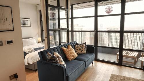 a living room with a blue couch and a bed at London Iconic View Retreat in London