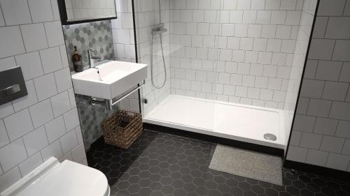 a bathroom with a sink and a tub and a toilet at London Iconic View Retreat in London
