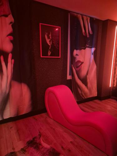 a room with a red couch in front of a mirror at Shiny Cloud Love Room in Limoux