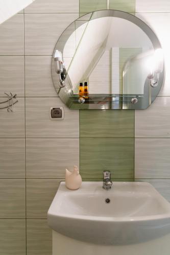 a bathroom with a sink and a mirror at TATRA COTTAGE góralski domek z kominkiem in Murzasichle