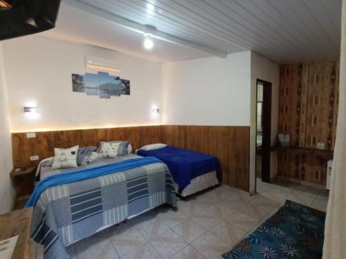 a bedroom with two beds in a room at Pousada e Restaurante Dona Siroba in Morretes