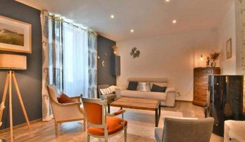 a living room with a couch and a table and chairs at Grande maison centre ville in Laval