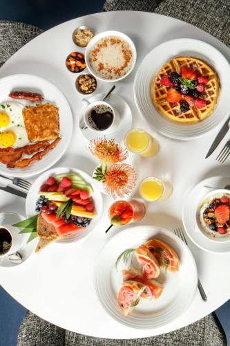 a white table topped with plates of breakfast foods at Le Meridien Dania Beach at Fort Lauderdale Airport in Dania Beach