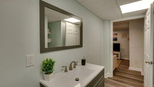 a bathroom with a sink and a mirror on the wall at Walk to Beach! Flamingle in Fuchsia, Whole House in Tybee Island
