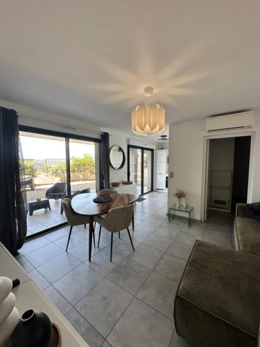 un salon avec une table et un canapé dans l'établissement super appartement F3 avec jardin, à Pietrosella