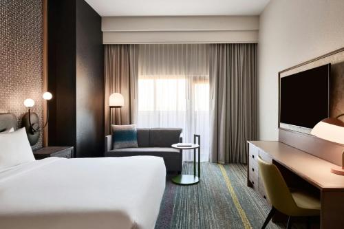 a hotel room with a bed and a chair and a desk at Renaissance Phoenix Glendale Hotel & Conference Center in Glendale
