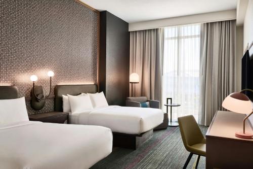 a hotel room with two beds and a chair at Renaissance Phoenix Glendale Hotel & Conference Center in Glendale