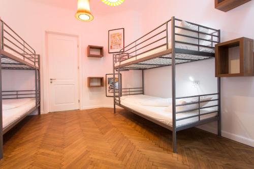 a room with two bunk beds and a wooden floor at First Hostel in Bucharest