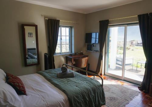 a bedroom with a bed and a sliding glass door at The Cão & Calf in Faja Grande